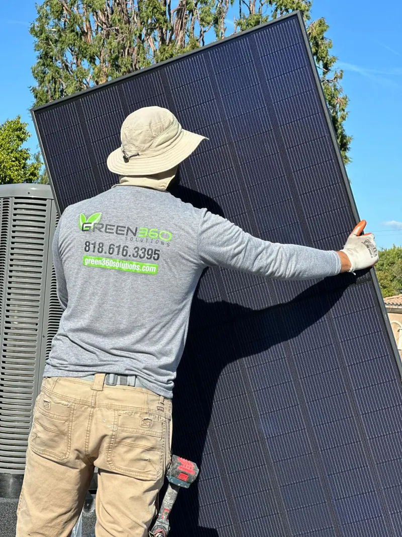 Green360 installer carrying a solar panel